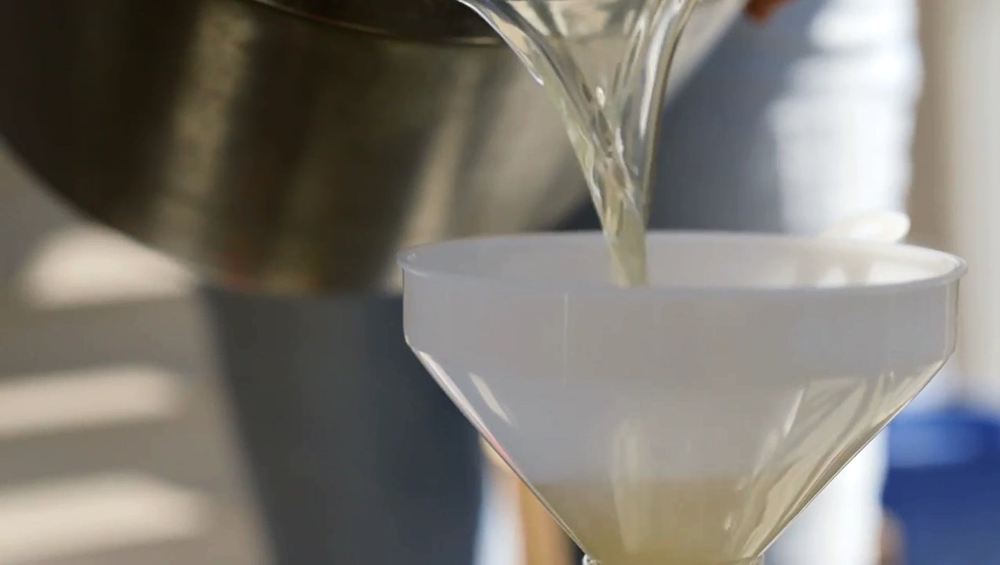 pouring must into a funnel before fermentation of mead